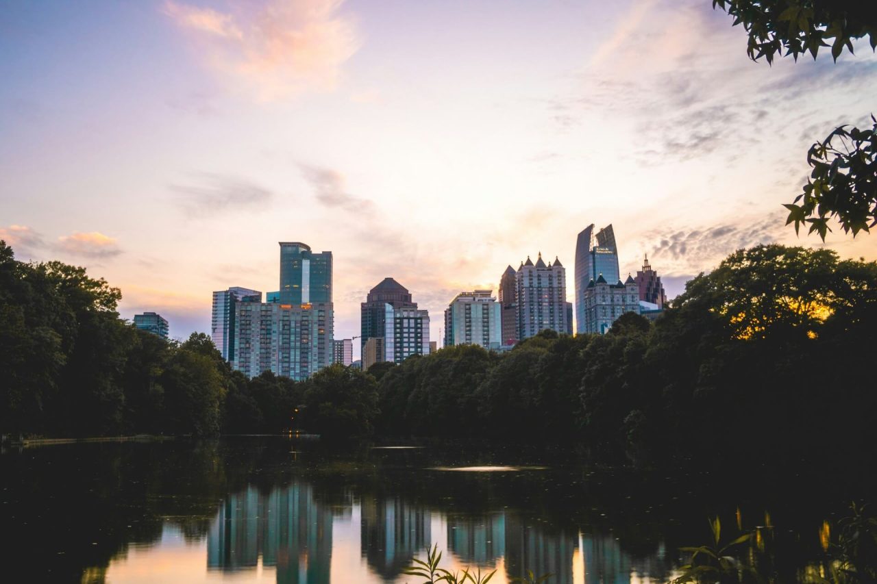A scenic view of a calm body of water surrounded by lush green trees during the daytime