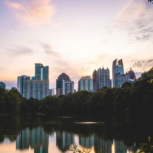 A scenic view of a calm body of water surrounded by lush green trees during the daytime